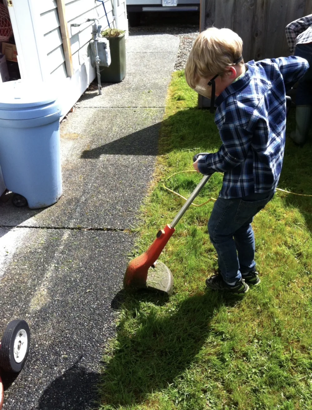 Matthew Hutchison at age four using a string trimmer on a Nanaimo lawn