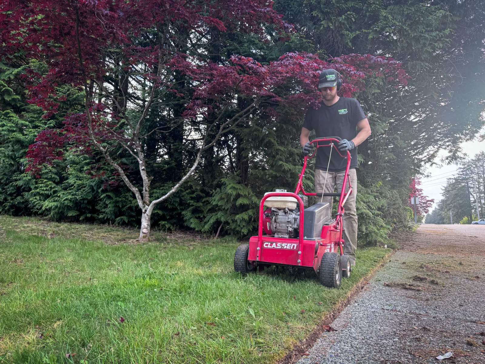 Matthew running a Classen core aerator across a Vancouver Island residential lawn