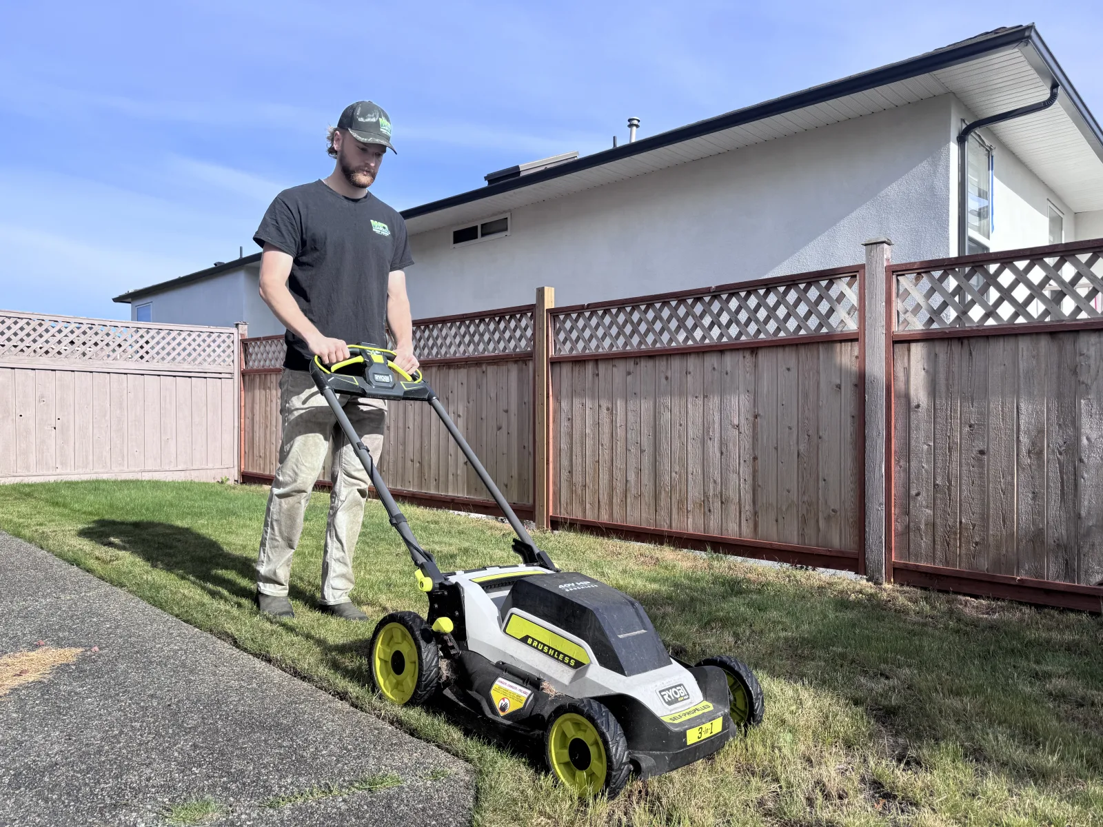 WCL crew member mowing a Nanaimo lawn with a battery-powered self-propelled electric mower