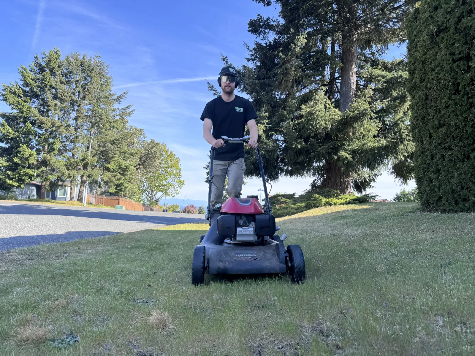 Matthew Hutchison, founder of West Coast Landscaping, mowing a lawn in Nanaimo