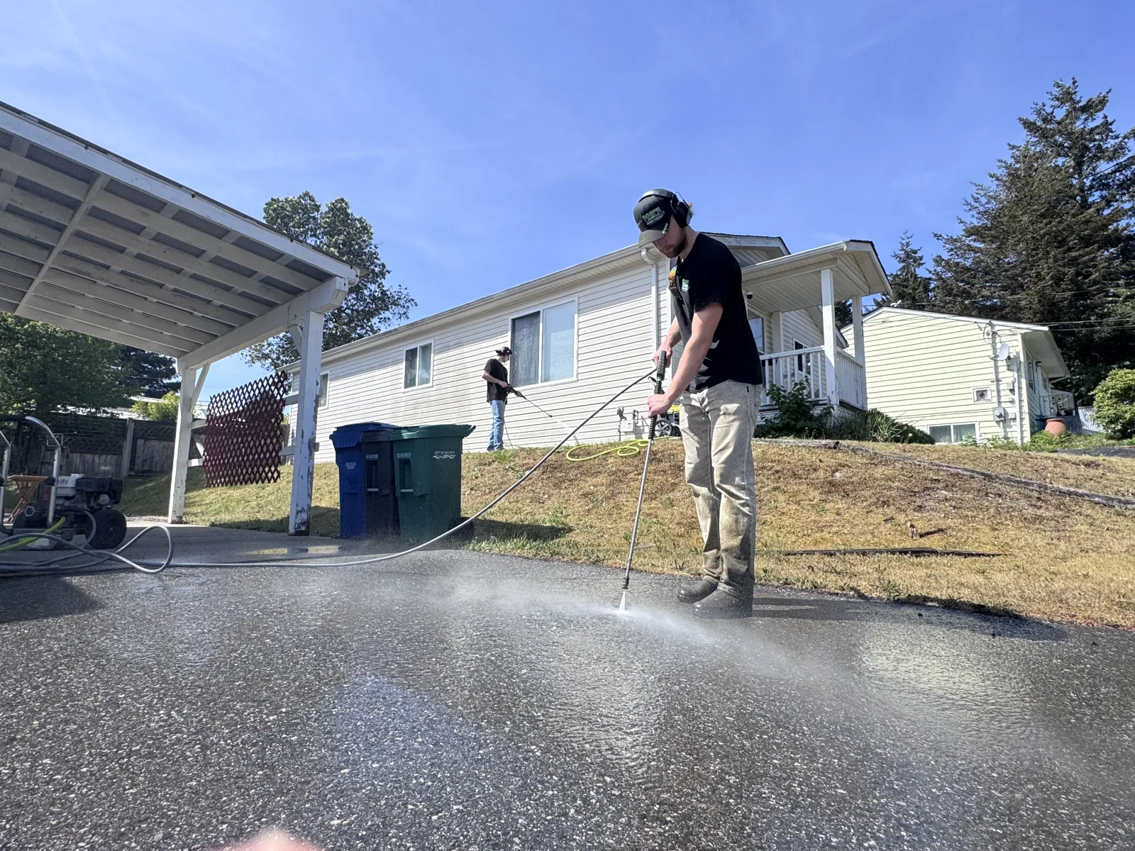 Matthew and Joey pressure-washing a driveway in Nanaimo for West Coast Landscaping